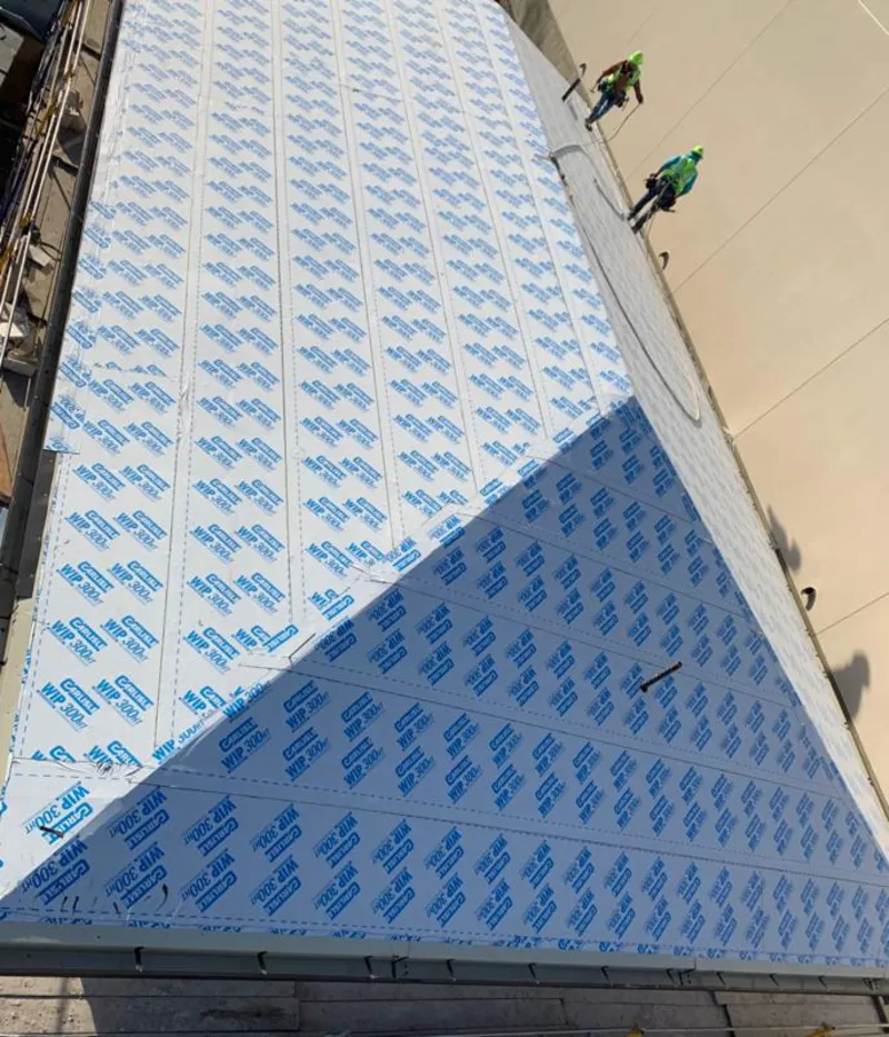 Professional roofers installing underlayment on a metal roof in Exeter